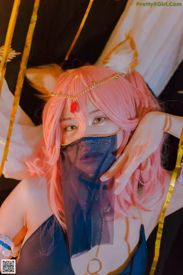 A woman with pink hair wearing a mask.