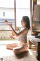 A woman sitting on the floor in front of a window.