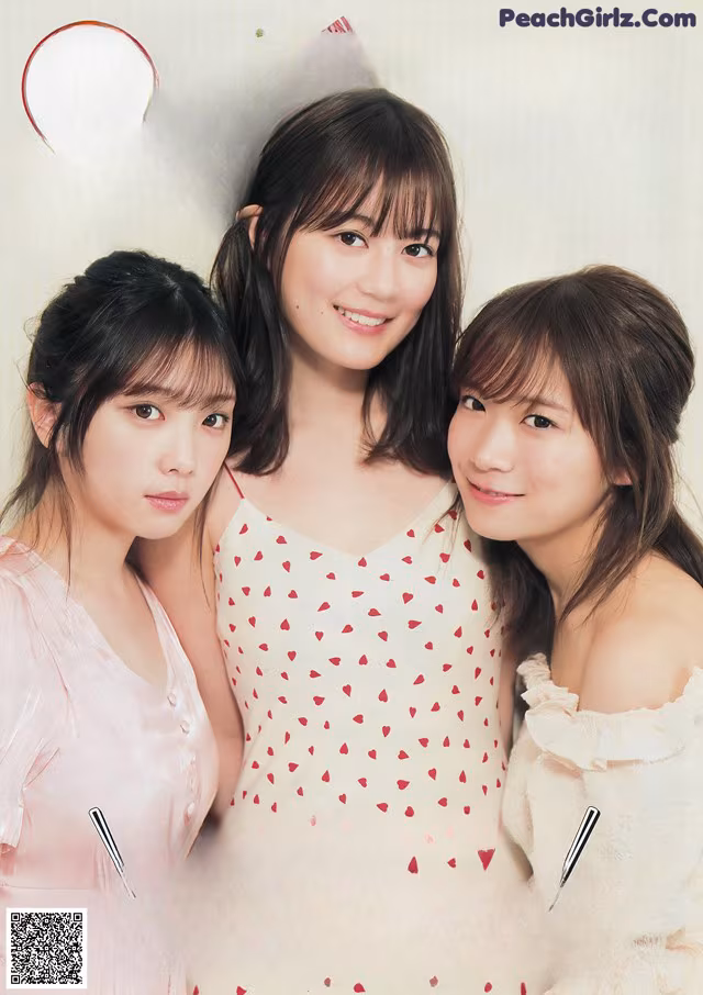 A group of three young women standing next to each other.