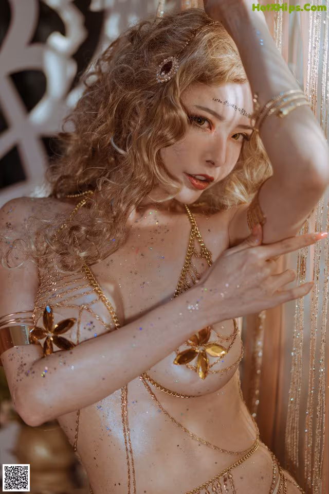 A woman in a gold bikini posing for a picture.