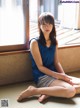 A woman sitting on the floor in front of a window.