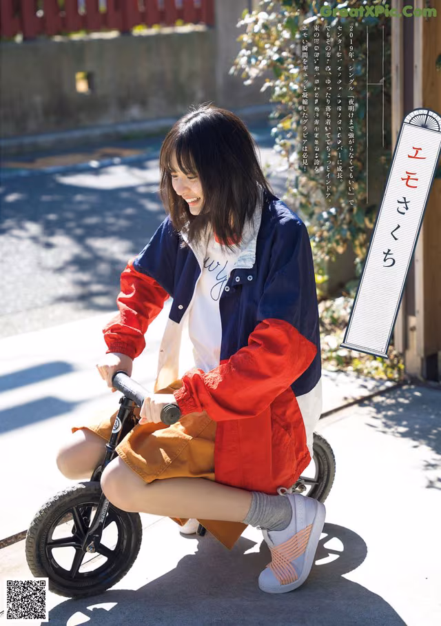 A woman sitting on a small bike on a sidewalk.