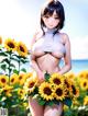 A woman in a white bikini standing in a field of sunflowers.