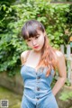 A woman in a denim jumpsuit posing for a picture.