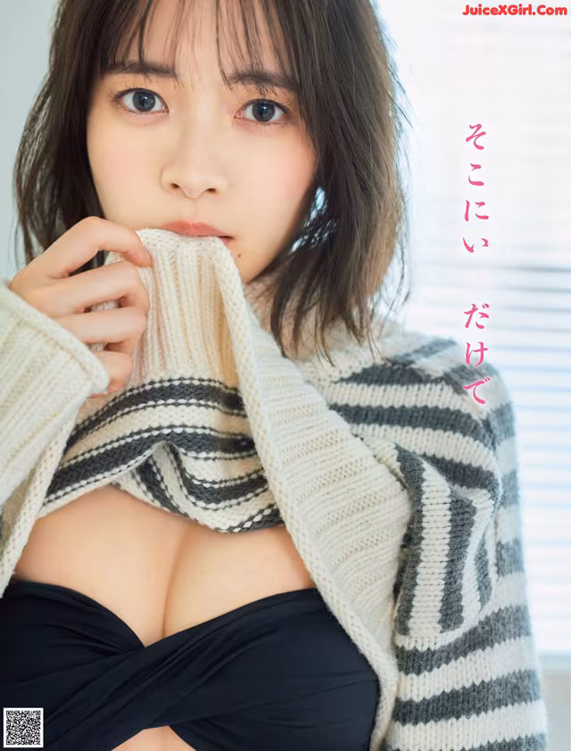 A woman in a black top and a striped sweater.