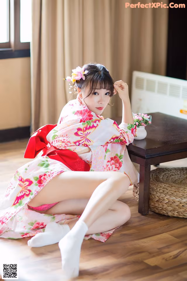 A woman in a kimono sitting on the floor.