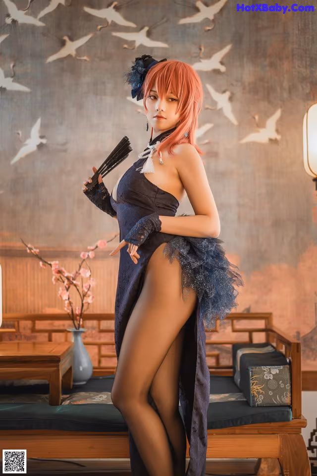 A woman in a black dress holding a fan.