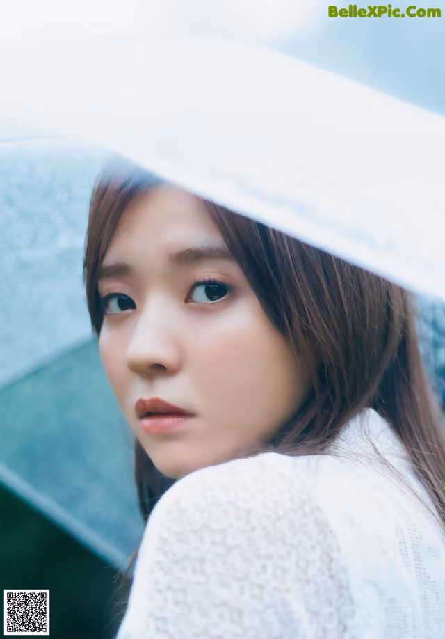 A woman with long brown hair wearing a white hat.