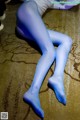 A woman in blue tights laying on the floor.