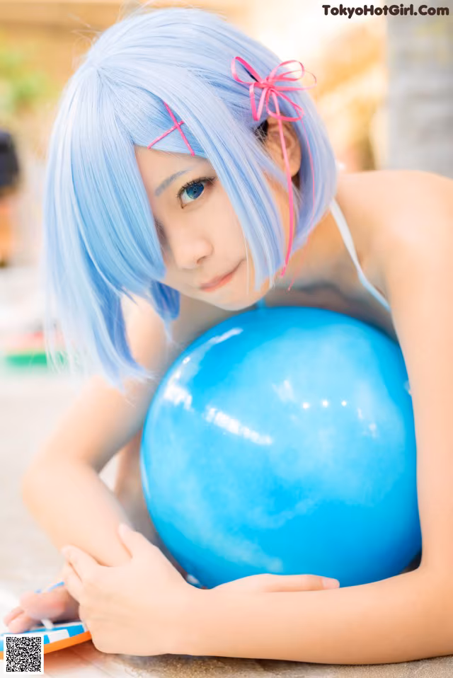 A woman with blue hair holding a blue ball.